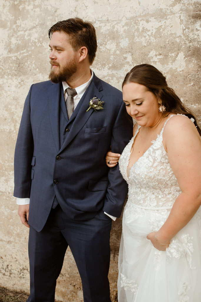 couple on wedding day during first look with soft smiles linking arms