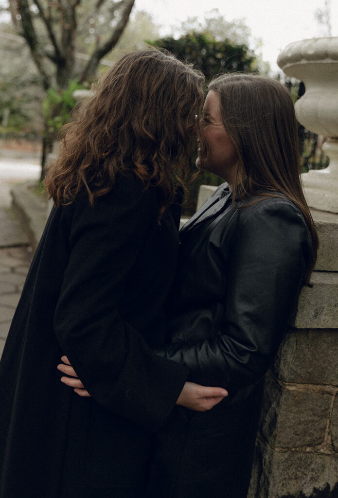 A close, tender portrait of an LGBTQ+ couple sharing a quiet moment during their engagement shoot in Inman Park. The photo highlights authentic emotion and a relaxed, documentary approach.