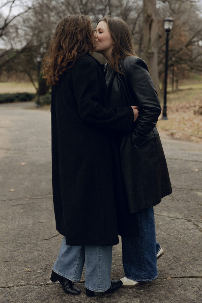An LGBTQ+ couple embraces warmly under the soft glow of golden hour in Inman Park, Atlanta. Their smiles and body language reflect a deeply personal, documentary-style engagement session.