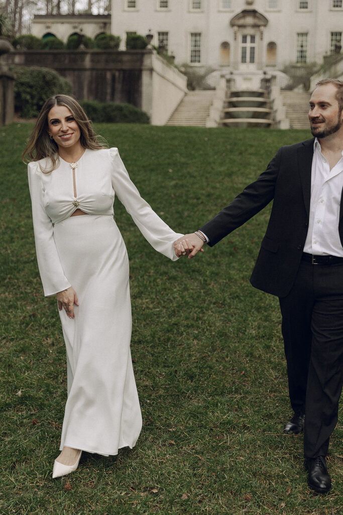 Couple walking hand-in-hand in front of the Swan House fountain in Atlanta